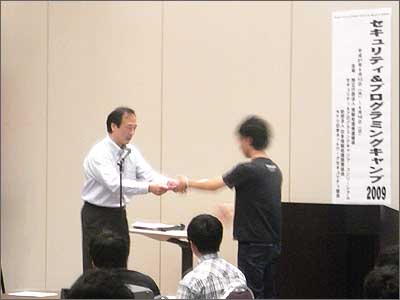 写真1 学生全員に三輪信雄実行委員長から修了証が手渡された。